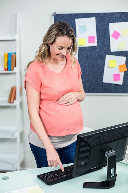 Pregnant woman using computer on a desk