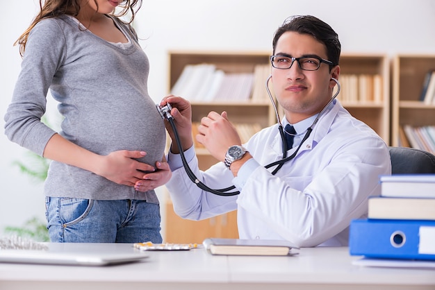 Medico in visita della donna incinta per consultazione