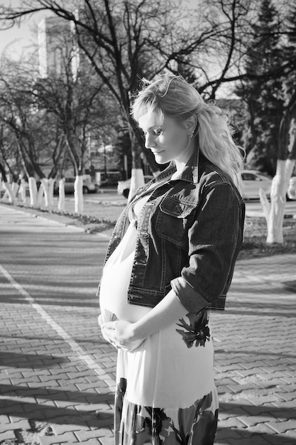 pregnant woman on the walk on city park in autumn day