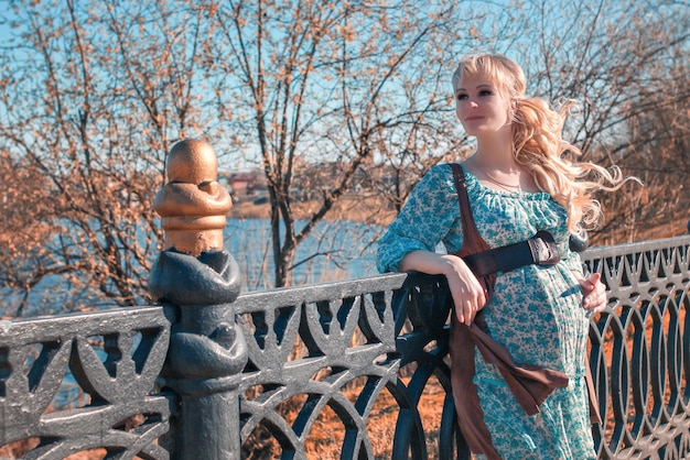 Pregnant woman on the walk on city park in autumn day