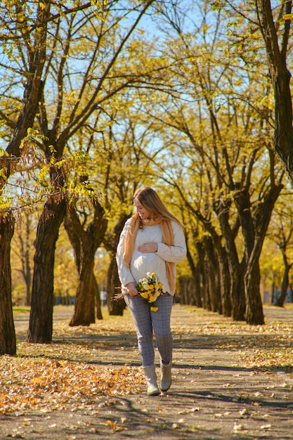 Pregnant woman walking in park and dreaming