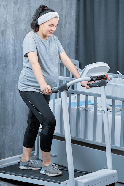 Pregnant woman walks on treadmill at home