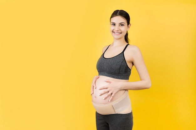 pregnant woman wearing pregnancy corset against backpain