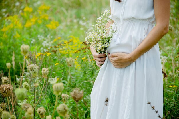 Photo pregnant woman in a white dress in a field