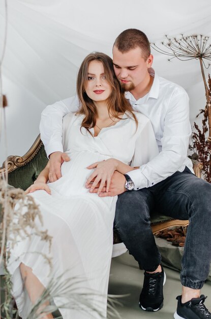 pregnant woman in a white dress with a man