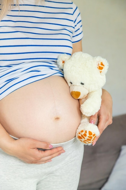 Pregnant woman and white teddy bear Selective focus