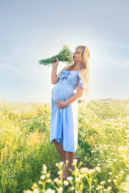 Pregnant woman with camomiles in hands