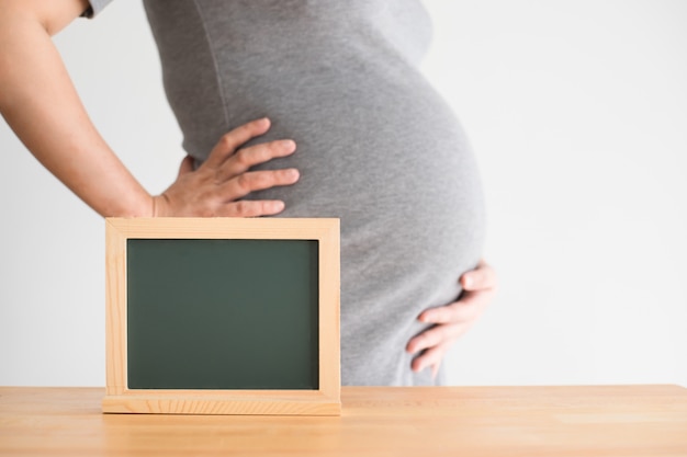 Pregnant woman with empty blackboard