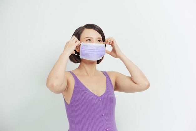 Pregnant woman with face medical mask on. Worries about child birth during pandemic.