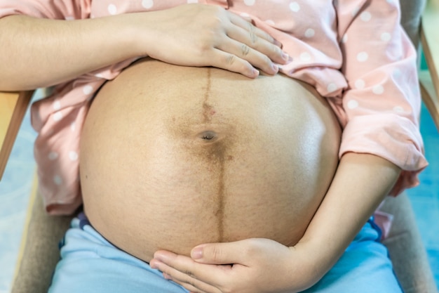 Donna incinta con le mani sulla pancia. maternità assistenza prenatale e concetto di gravidanza della donna.