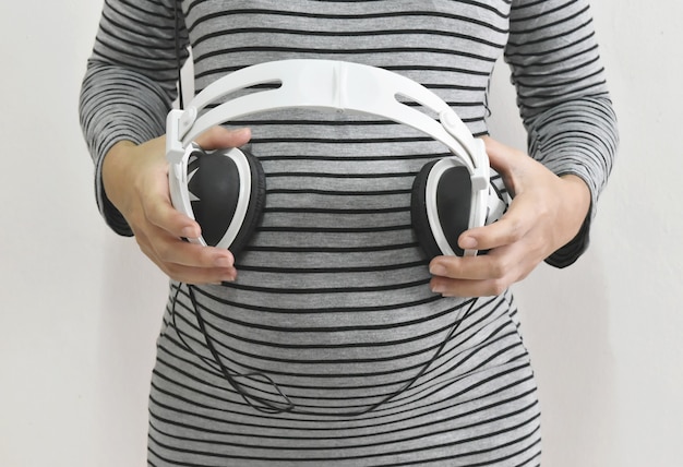 Pregnant woman with headphones.