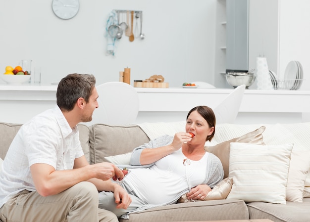 Pregnant woman with her husband eating strawberry