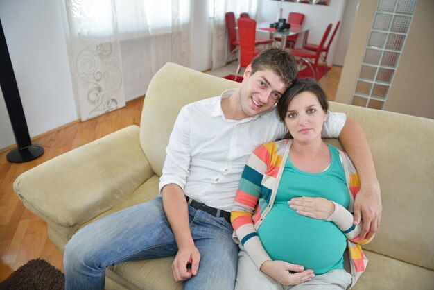 pregnant woman with her husband have fun relax and using tablet comture at modern home