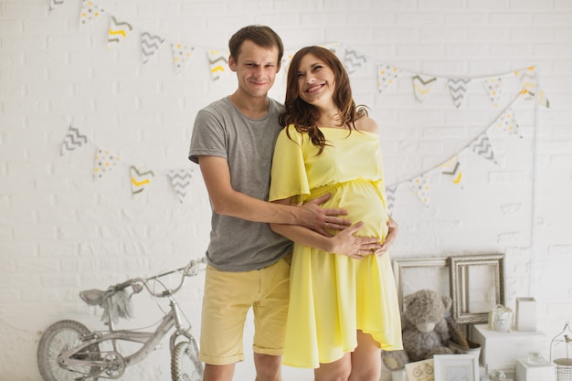 Pregnant woman with her husband in the studio