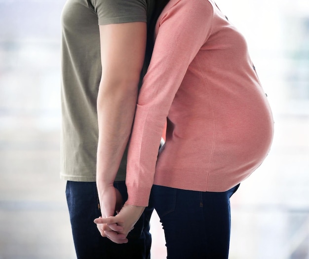 窓の前で夫と妊娠中の女性