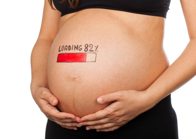 Pregnant woman with loading concept painted on her belly.