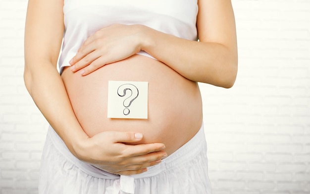 Беременная женщина с отметками бумажных наклейки на животе