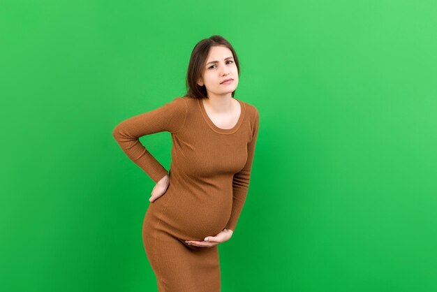 Foto donna incinta con un dolore alla schiena su sfondo colorato isolato