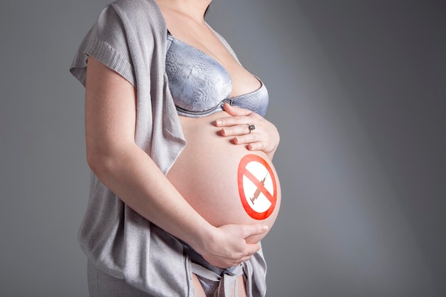 Pregnant woman with sign No drugs on her belly