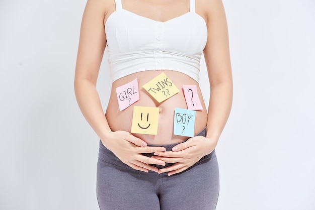 Pregnant woman with stick notes on her belly