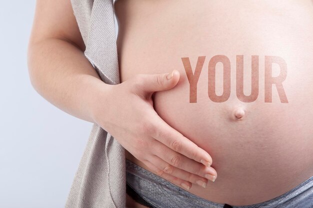 Pregnant woman with title your on her belly