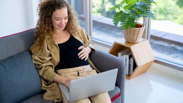 Foto donna incinta che lavora a casa