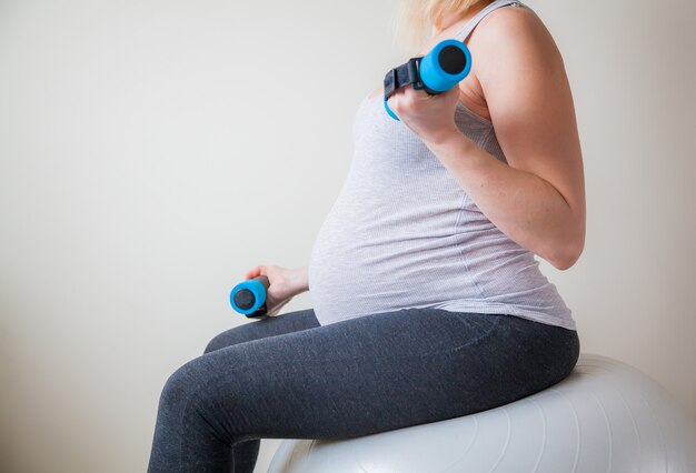 Pregnant woman working out with light weights