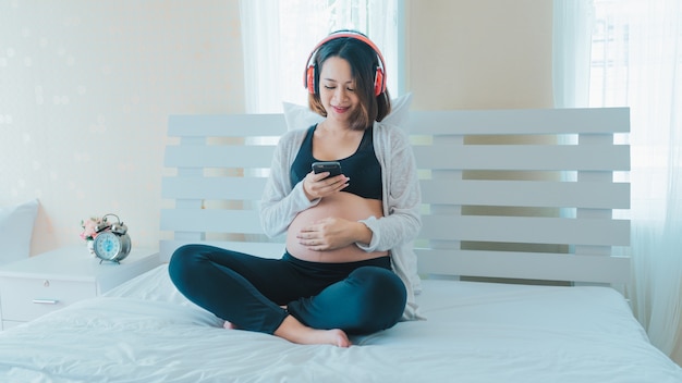 Foto le donne incinte ascoltano musica e suonano i telefoni