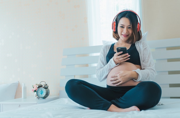 Foto le donne incinte ascoltano musica e suonano i telefoni