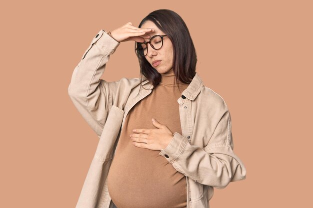 Photo pregnant young caucasian woman showcasing maternity having a head ache touching front of the face