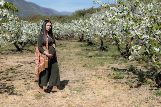 Pregnant young woman among cherry trees