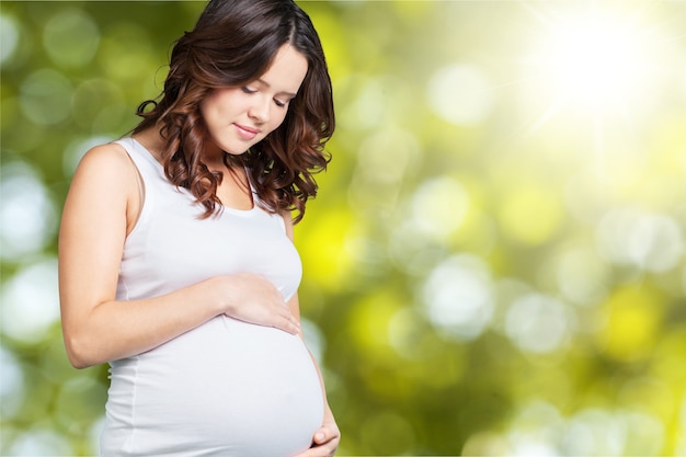 Pregnant young woman in white t shirt on  background