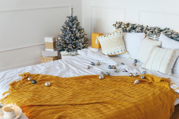 Preholiday christmas bustle christmas decorations scattered on the bed decorated with a garland in