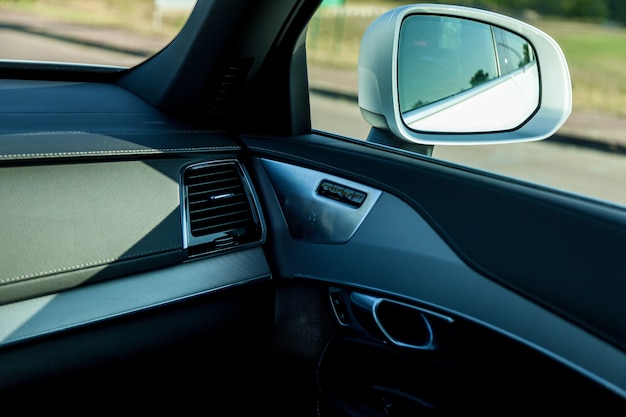 Premium car interior in black leather stitched with white thread