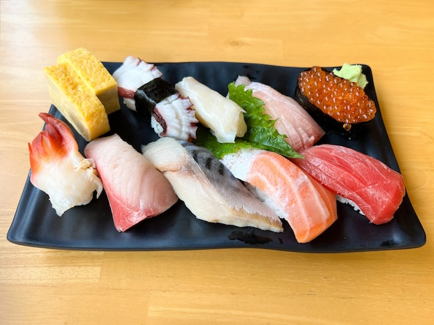 The premium Japanese sushi set place on black plate with wasabi