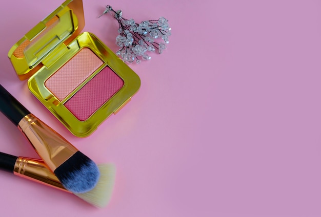 Premium make-up kwasten in make-up tas, blozen palet op een gekleurde roze achtergrond