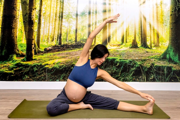 Пренатальная йога Инструктор по йоге для беременных делает упражнения йоги