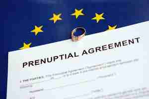 Photo prenuptial agreement and wedding ring on table premarital paperwork process in europe close up