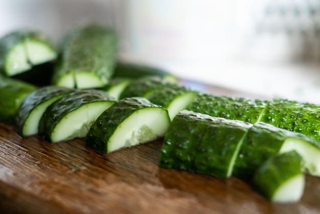 Preparation of beaten cucumbers Cut halves of fresh cucumbers on a cutting wooden board