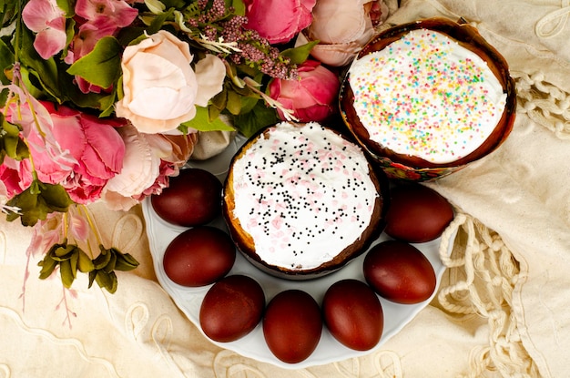 Preparazione per la celebrazione della pasqua. torta fatta in casa e uova di colore rosso. studio fotografico