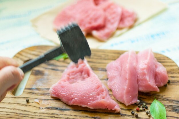 Preparation of chops Hand with a hammer beats a meat turkey chicken fillet