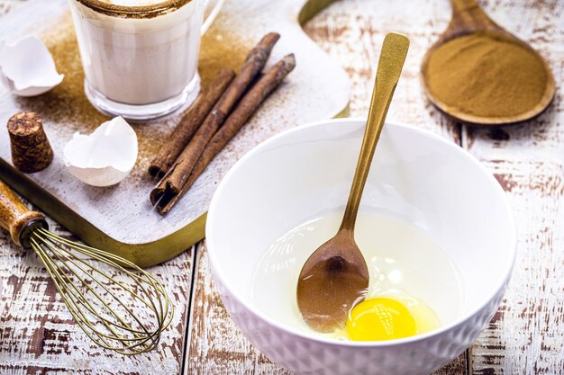 Preparation of Christmas eggnog, Christmas drink recipe, with eggs, sugar, cinnamon, rum and cream