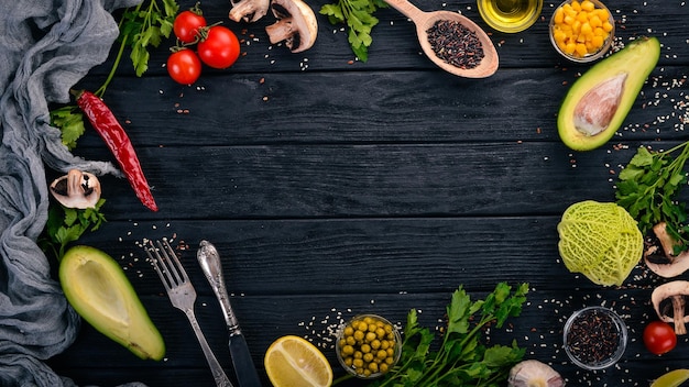 Preparation for cooking Avocados cherry tomatoes green peas and hazelnut On a wooden background Top view Free space for your text