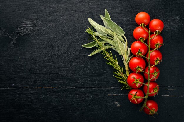 チェリートマトを調理するための準備木製の背景に新鮮な野菜とスパイス上面図