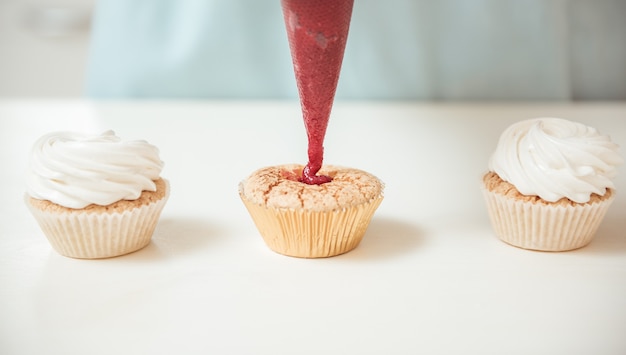 Photo preparation of cupcakes: berry cream squeezed from the top