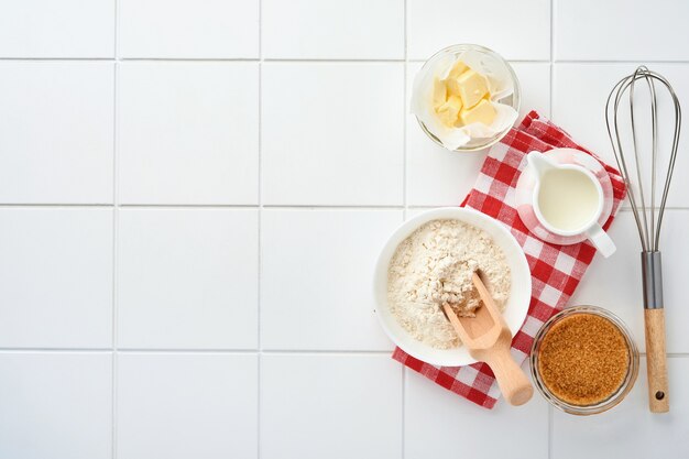 Preparation of dough for home pancakes for Breakfast or for Maslenitsa. Ingredients on the table - wheat flour, eggs, butter, sugar, salt, milk. Recipe step by step. Top view with place for text.