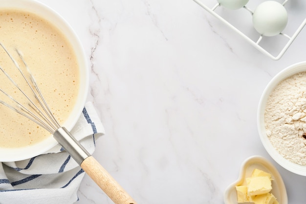 Preparazione dell'impasto per frittelle casalinghe per colazione o per maslenitsa. ingredienti sulla tavola farina di frumento, uova, burro, zucchero, sale, latte