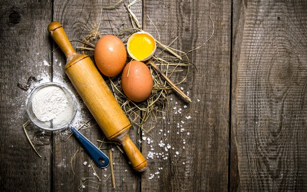 Preparation of the dough. Ingredients for the dough eggs with flour and with a rolling pin.