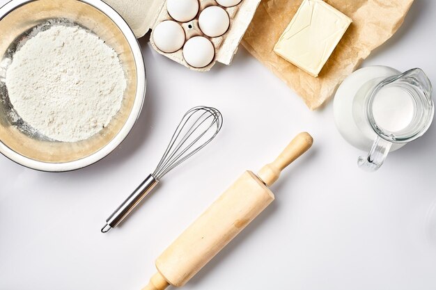 Photo preparation of the dough a measurement of the amount of ingredients in the recipe ingredients for the dough flour eggs rolling pin whisk milk butter cream top view space for text