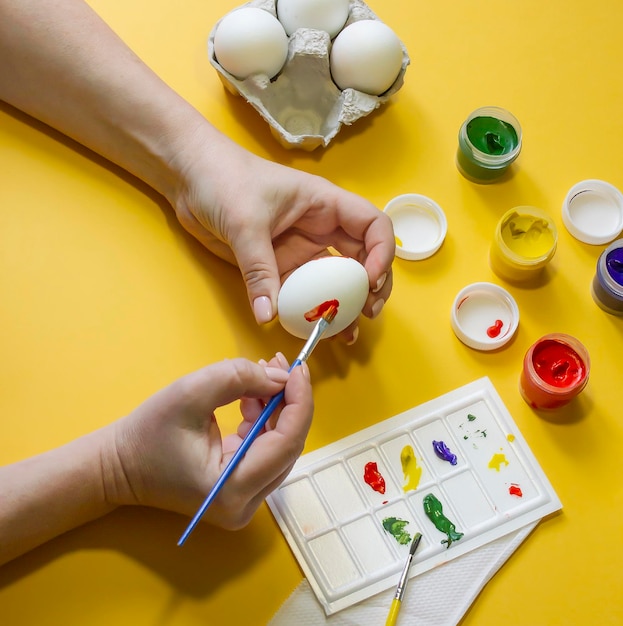 Foto preparazione per la pasqua le mani femminili dipingono le uova di gallina per celebrare la pasqua